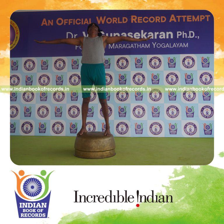individual holding pirai chaturmukha trikonasana yoga pose blindfolded on a vessel for record in Indian Book of Records
