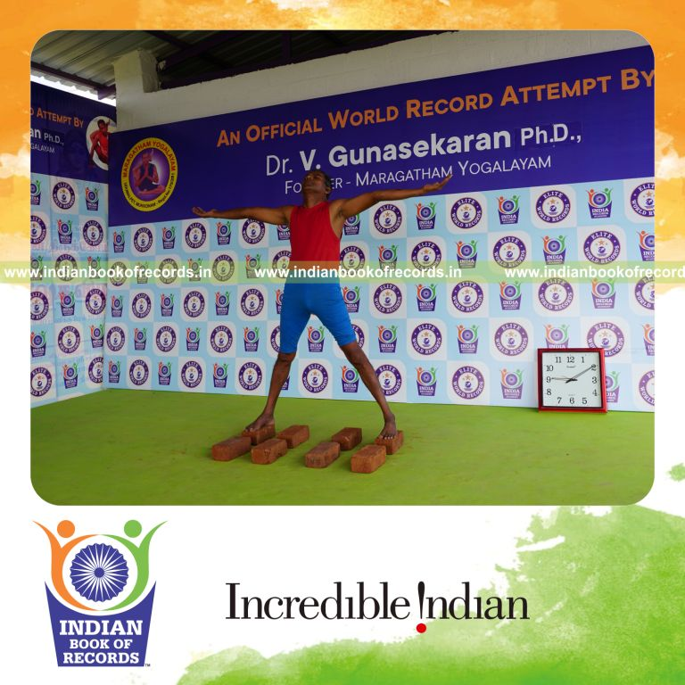 individual holding pirai chaturmukha trikonasana yoga pose on bricks for record in Indian Book of Records
