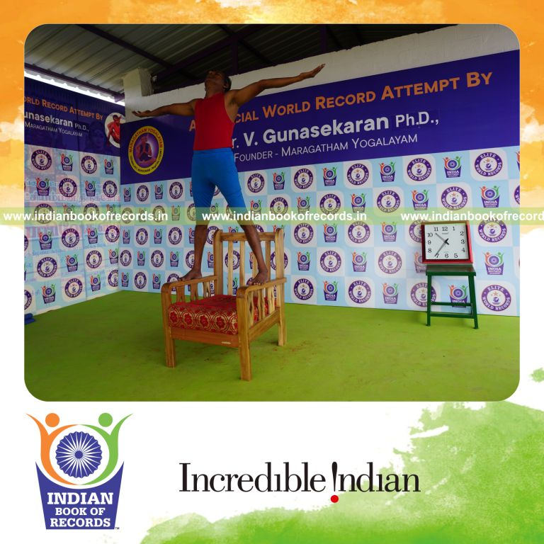 individual holding pirai chaturmukha trikonasana yoga pose on a chair for record in Indian Book of Records
