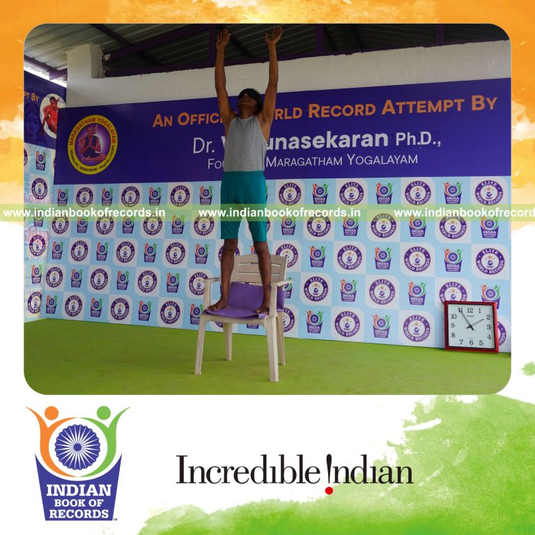 individual holding piraiasana yoga pose blindfolded on a chair for record in Indian Book of Records