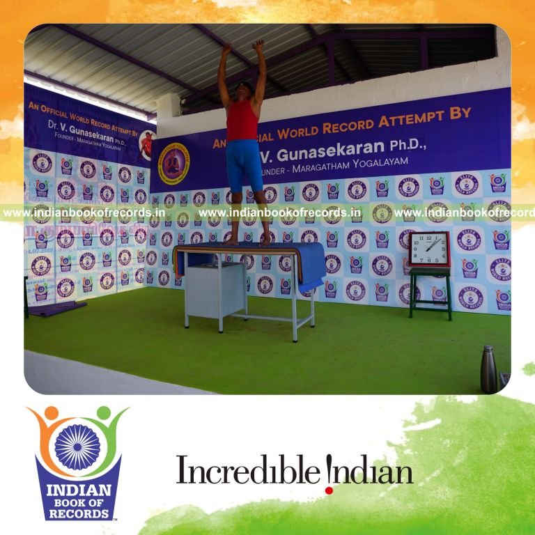 individual holding piraiasana yoga pose blindfolded on a table for record in Indian Book of Records