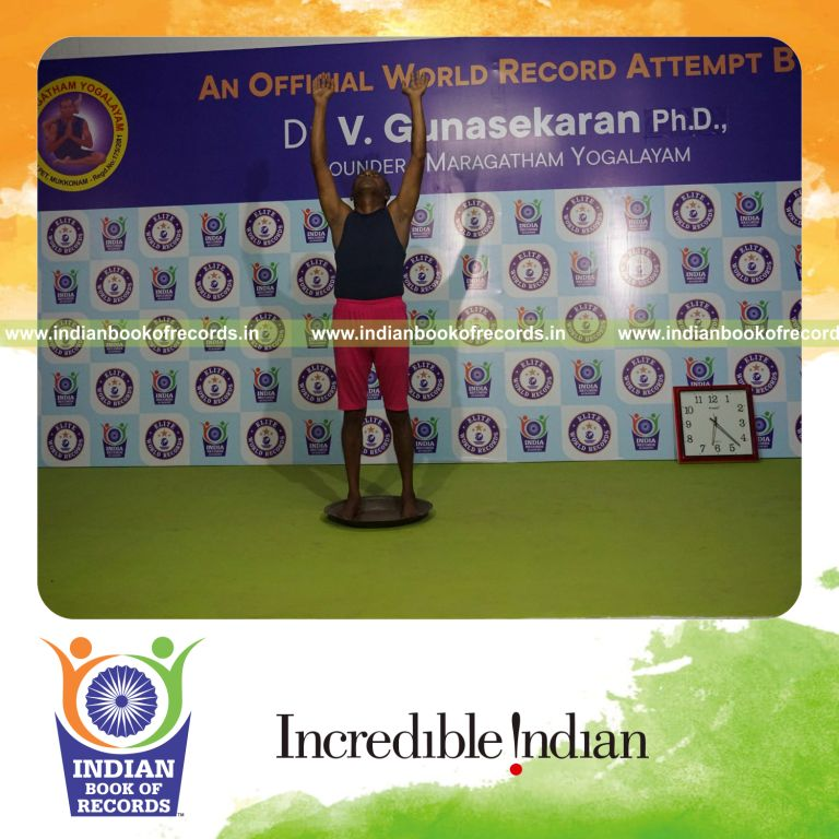 individual holding piraiasana yoga pose on a brass plate for record in Indian Book of Records