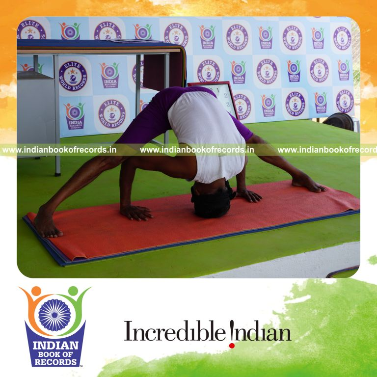 individual holding prasaritha padhottasana yoga pose blindfolded for record in Indian Book of Records