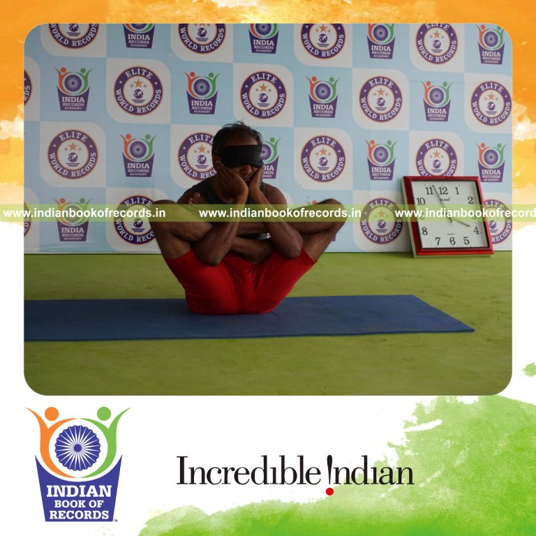 individual holding purna garbha pindasana yoga pose blindfolded for record in Indian Book of Records