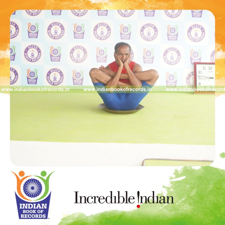 individual holding purna garbha pindasana yoga pose on a brass plate for record in Indian Book of Records