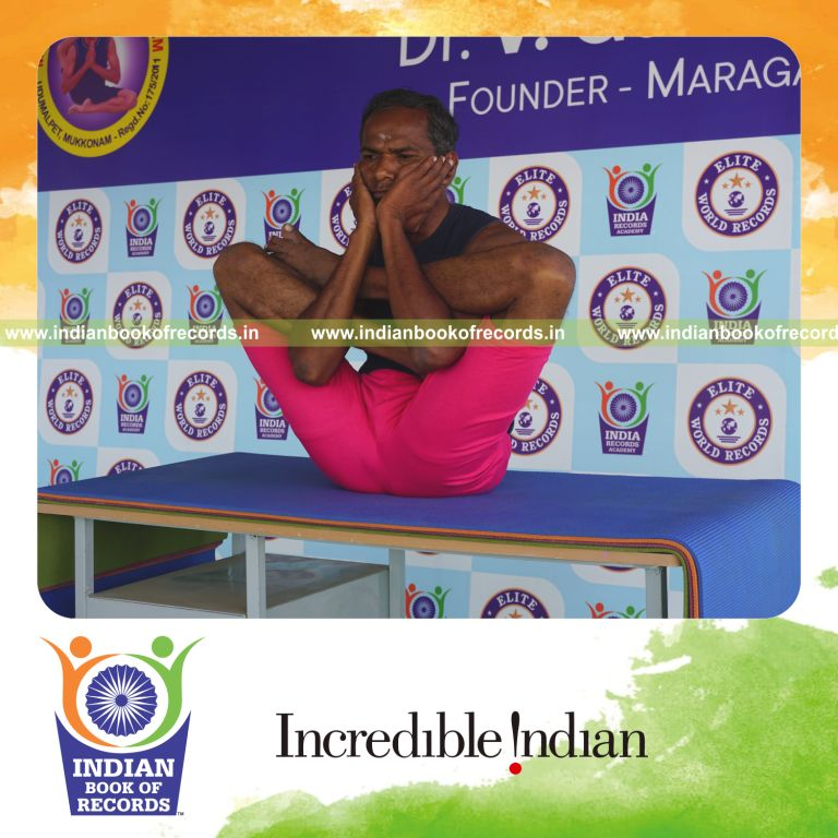 an individual holding purna garbha pindasana yoga pose on a table for the longest duration with flexibility and control for a record in Indian Book of Records