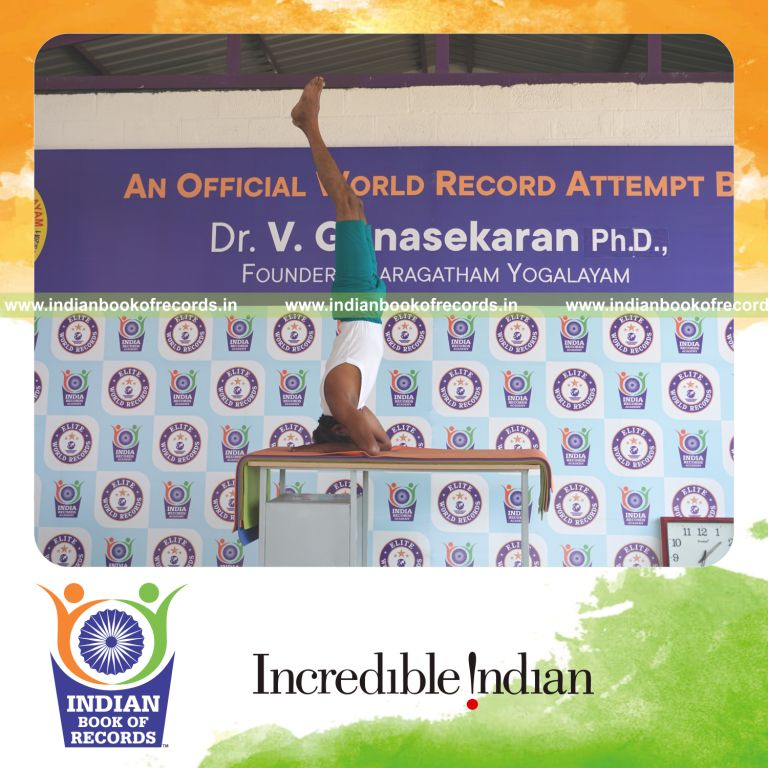 an individual holding salamba sirsasana yoga pose blindfolded on a table continuously for the longest duration with balance and control for a record in Indian Book of Records