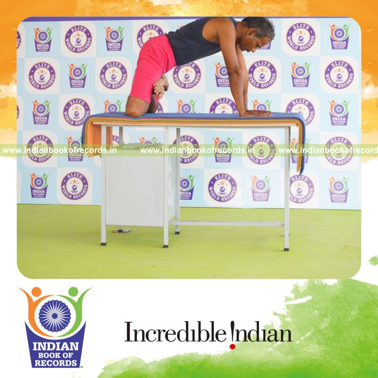 individual holding simhasana yoga pose on a table for record in Indian Book of Records