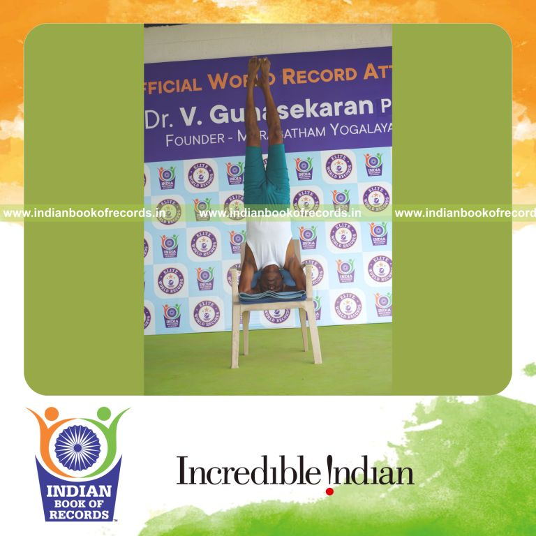 individual holding sirasasana yoga pose on a chair for record in Indian Book of Records
