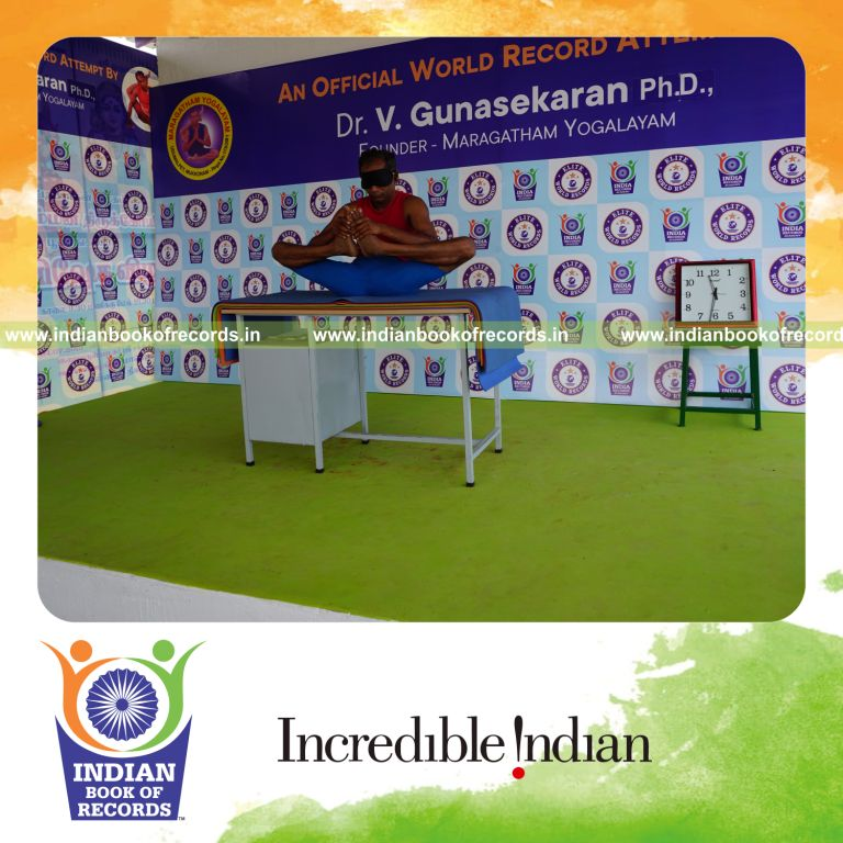 individual holding skandasana yoga pose blindfolded on a table for record in Indian Book of Records