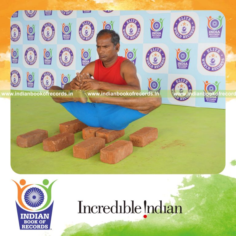 individual holding skandasana yoga pose on bricks for record in Indian Book of Records