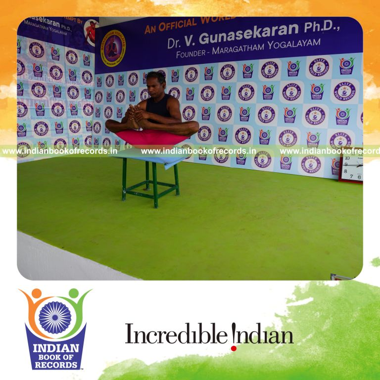 individual holding skandasana yoga pose on a stool for record in Indian Book of Records