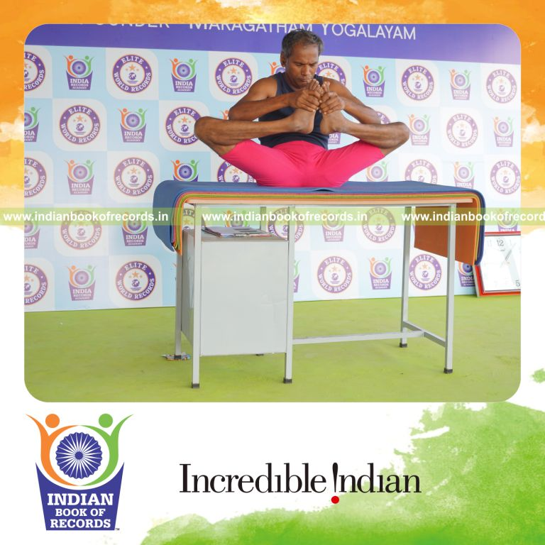 individual holding skandasana yoga pose on a table for record in Indian Book of Records