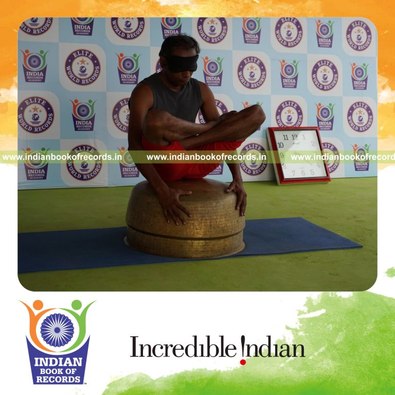 individual holding thulangasana yoga pose blindfolded on a vessel for record in Indian Book of Records