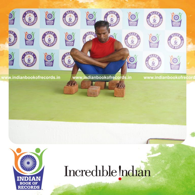 individual holding thulangasana yoga pose on bricks for record in Indian Book of Records