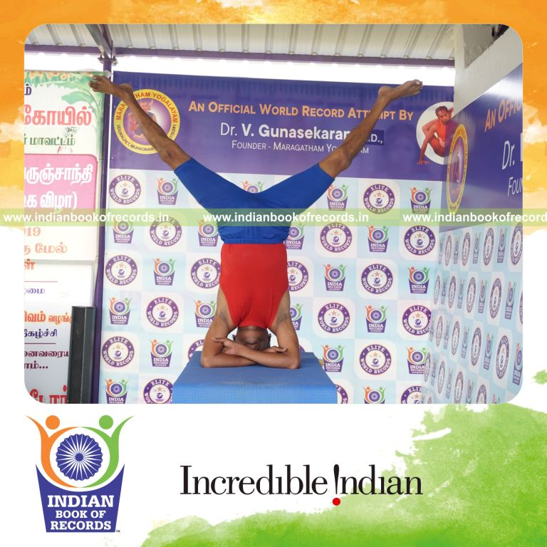 individual holding upavistha baddha hastha sirsasana yoga pose on a table for record in Indian Book of Records