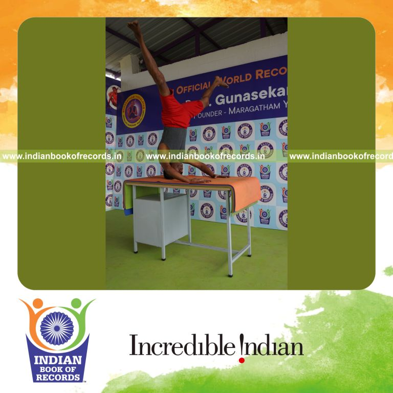 individual holding upavistha mukta sirsasana yoga pose blindfolded on a table for record in Indian Book of Records
