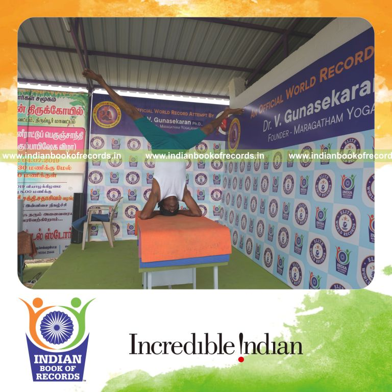 an individual holding upavistha salamba sirsasana yoga pose blindfolded on a table continuously for the longest duration with stability and control for a record in Indian Book of Records