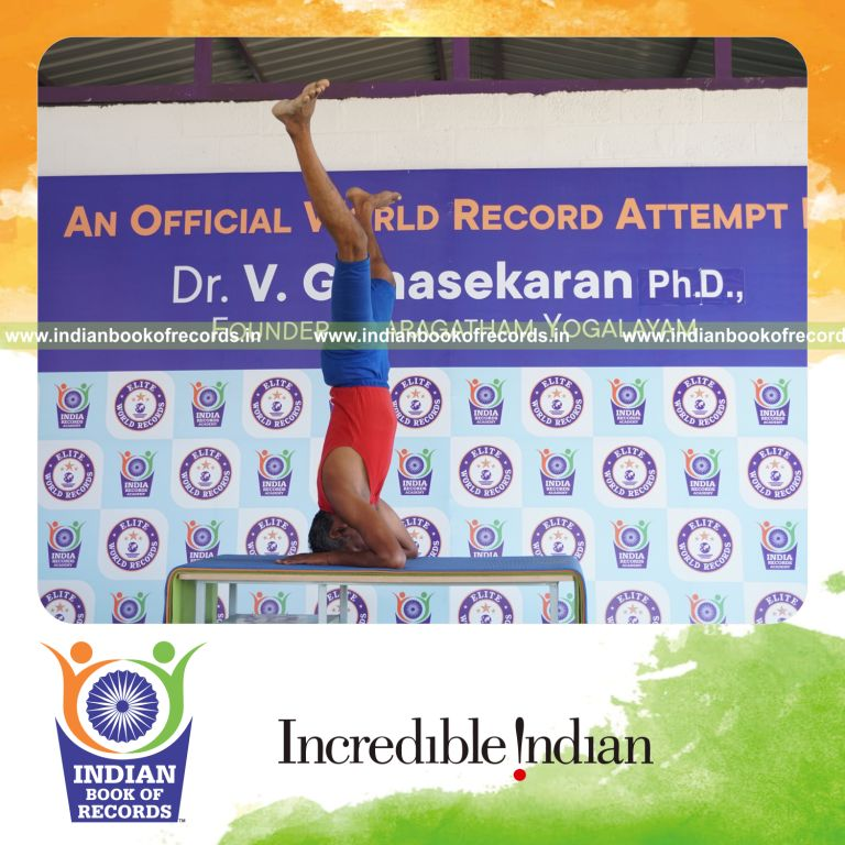 individual holding upavistha salamba sirsasana yoga pose on a table for record in Indian Book of Records