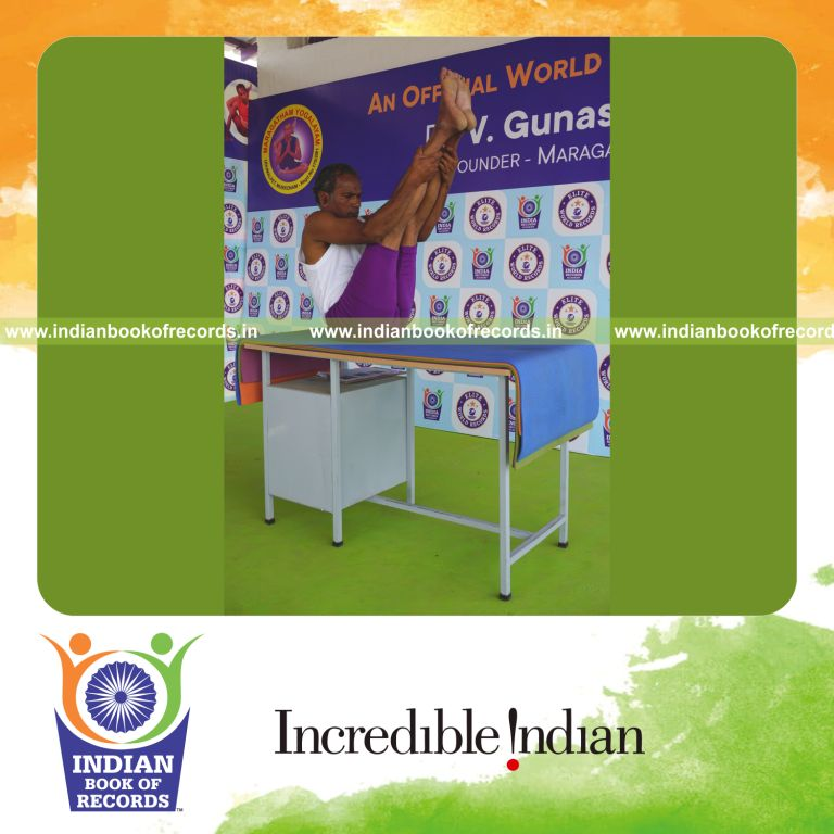 individual holding urdhva mukha paschimottanasana yoga pose on a table for record in Indian Book of Records