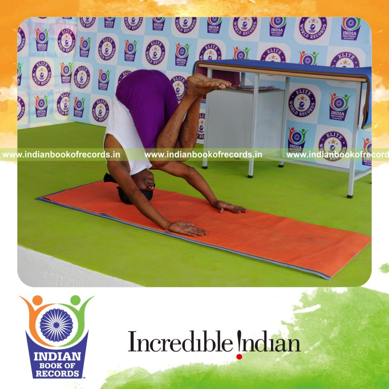 individual holding urdhva mukta sirsasana yoga pose blindfolded for record in Indian Book of Records