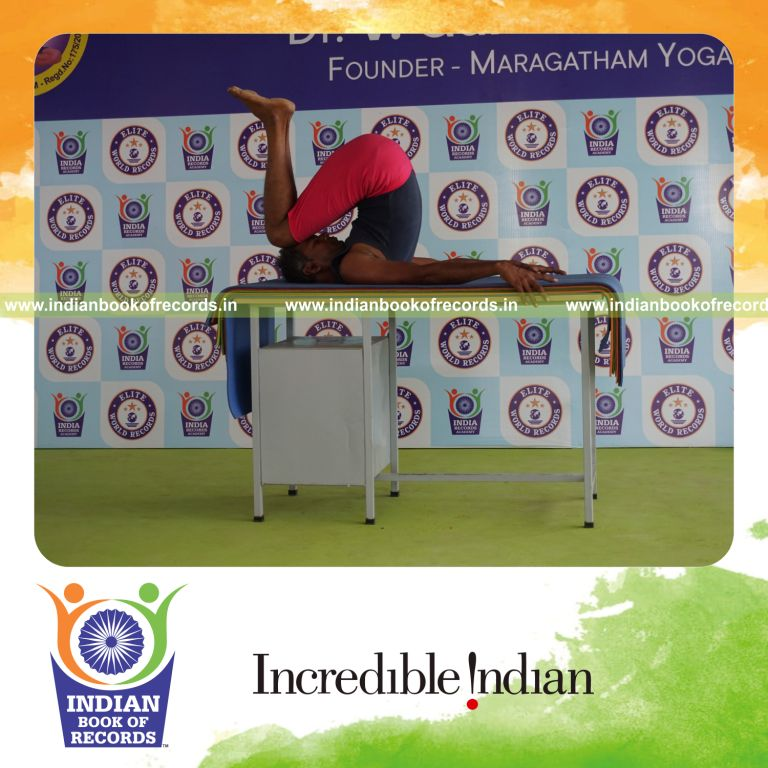 individual holding urdhva salamba sarvangasana yoga pose on a table for record in Indian Book of Records