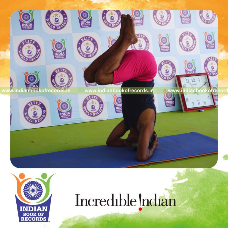 an individual holding urdhva sirsasana yoga pose blindfolded for the longest duration with strength and balance for a record in Indian Book of Records