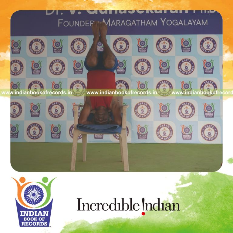 individual holding urdhva sirsasana yoga pose on a chair for record in Indian Book of Records