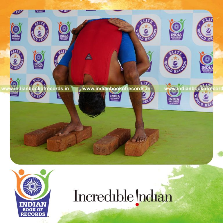 individual holding uthitha titibasana yoga pose on bricks for record in Indian Book of Records