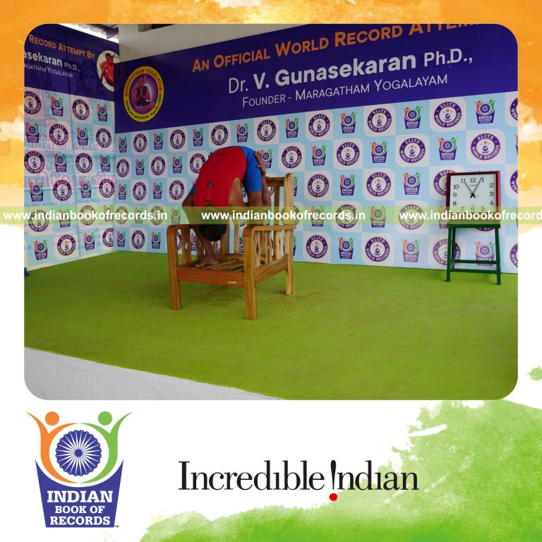 individual holding uthitha titibasana yoga pose on a chair for record in Indian Book of Records