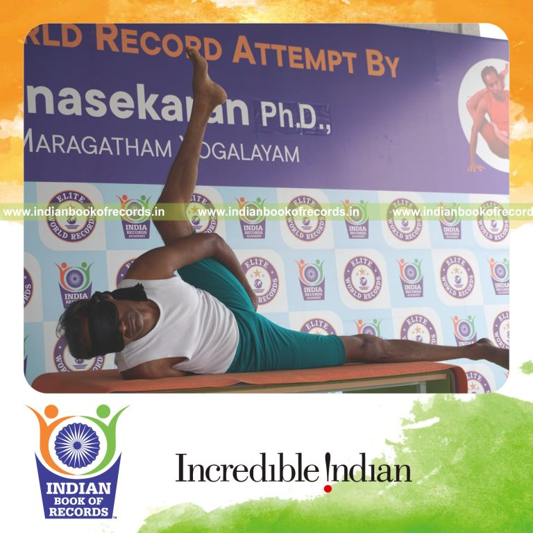 an individual holding vama ananda ardha matsyendrasana yoga pose blindfolded on a table continuously for the longest duration with stability and control for a record in Indian Book of Records