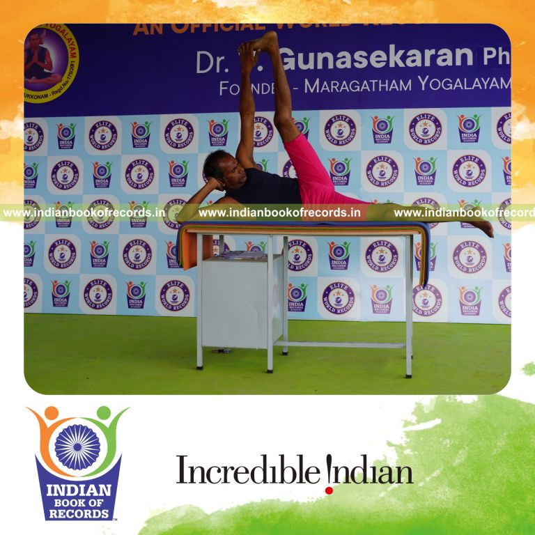 individual holding vama anandasana yoga pose on a table for record in Indian Book of Records