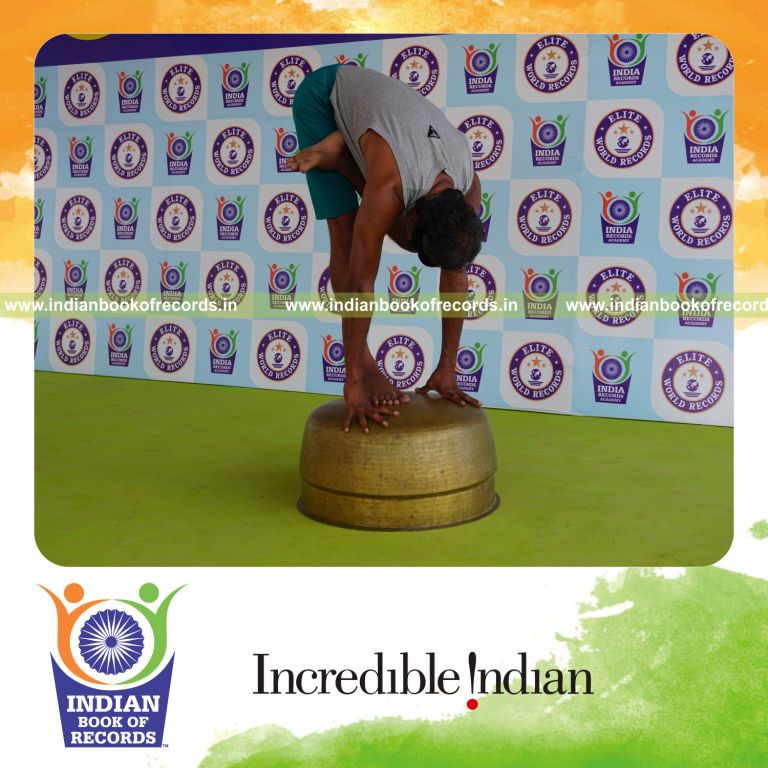 individual holding vama ardha baddha padmottasana yoga pose blindfolded on a vessel for record in Indian Book of Records