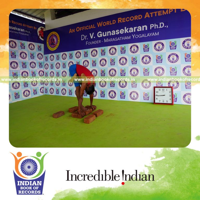 individual holding vama ardha baddha padmottasana yoga pose on bricks for record in Indian Book of Records