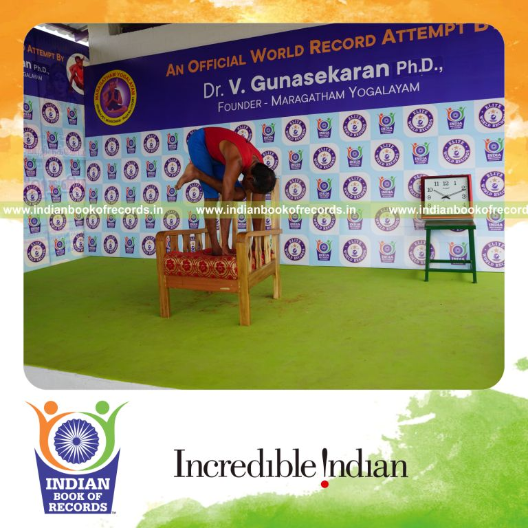 individual holding vama ardha baddha padmottasana yoga pose on a chair for record in Indian Book of Records
