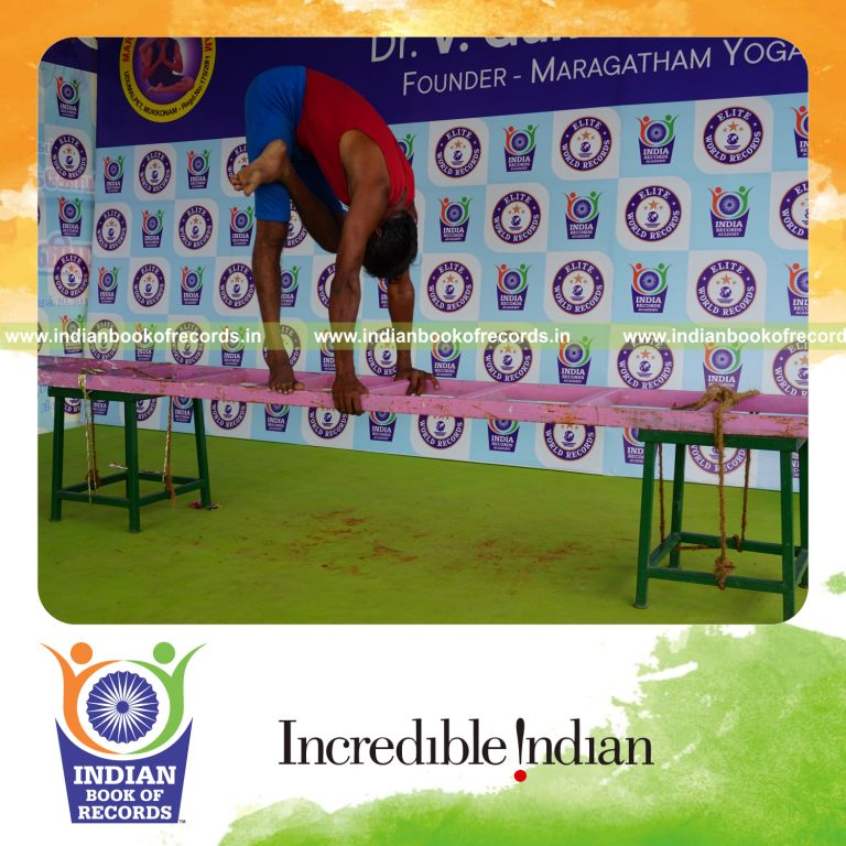 individual holding vama ardha baddha padmottasana yoga pose on a ladder for record in Indian Book of Records