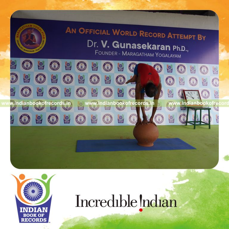 individual holding vama ardha baddha padmottasana yoga pose on a pot for record in Indian Book of Records