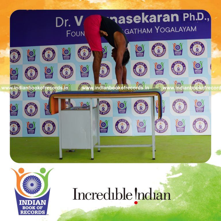 individual holding vama ardha baddha padmottasana yoga pose on a table for record in Indian Book of Records