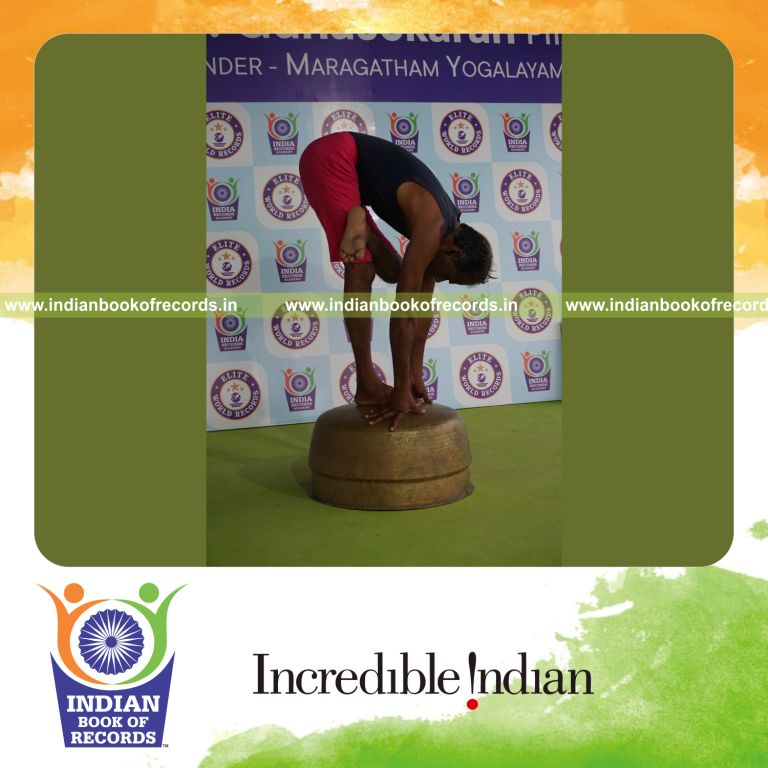 individual holding vama ardha baddha padmottasana yoga pose on a vessel for record in Indian Book of Records