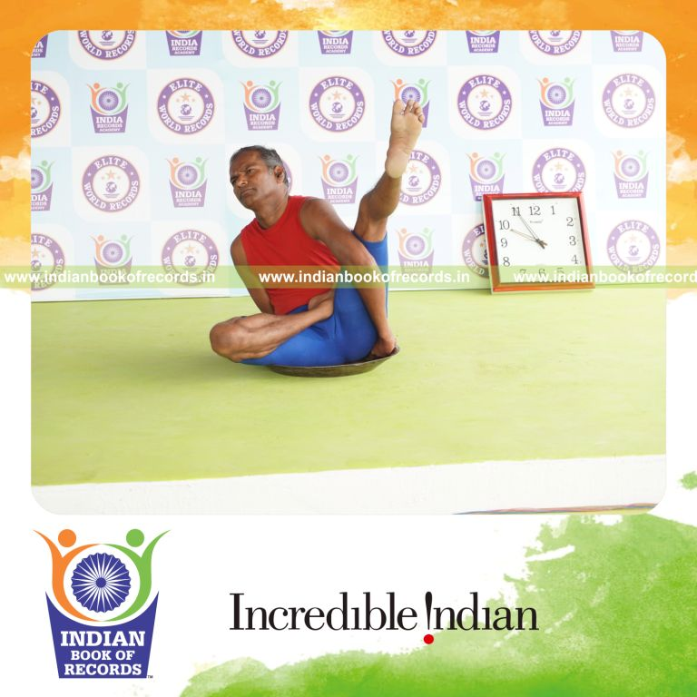 individual holding vama ardha baddha parsva krounchasana yoga pose on a brass plate for record in Indian Book of Records
