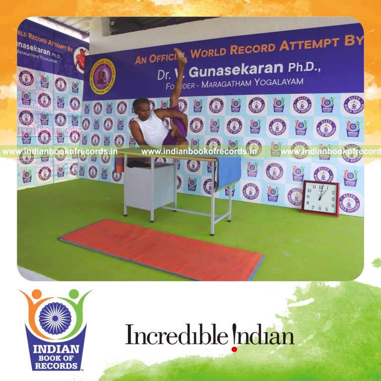 individual holding vama ardha baddha parsva krounchasana yoga pose on a table for record in Indian Book of Records