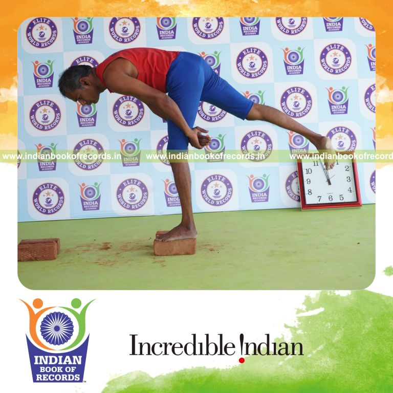 individual holding vama ardha chandra virabhadrasana yoga pose on bricks for record in Indian Book of Records