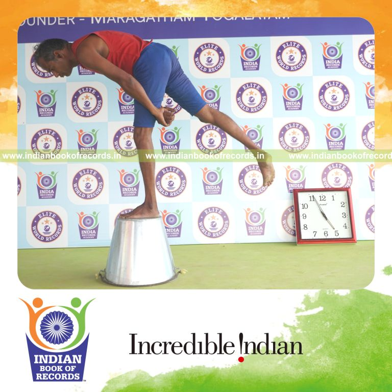 individual holding vama ardha chandra virabhadrasana yoga pose on a bucket for record in Indian Book of Records