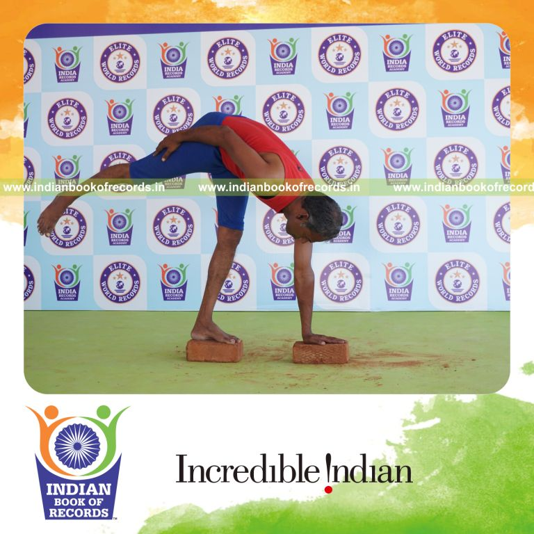 individual holding vama ardha chandrasana yoga pose on bricks for record in Indian Book of Records