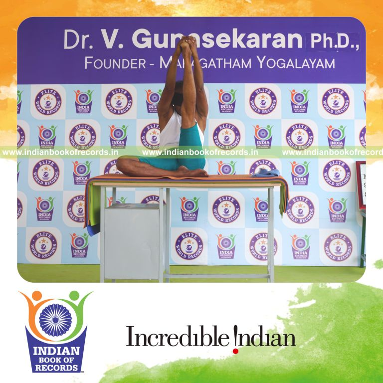 an individual holding vama ardha krounchasana yoga pose blindfolded on a table continuously for the longest duration with control and balance for a record in Indian Book of Records