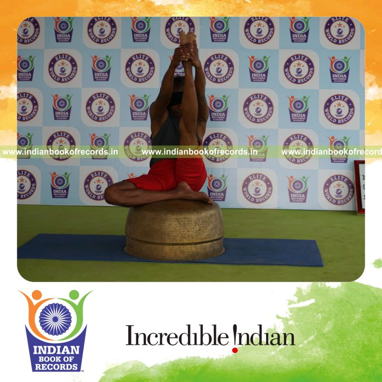 individual holding vama ardha krounchasana yoga pose blindfolded on a vessel for record in Indian Book of Records
