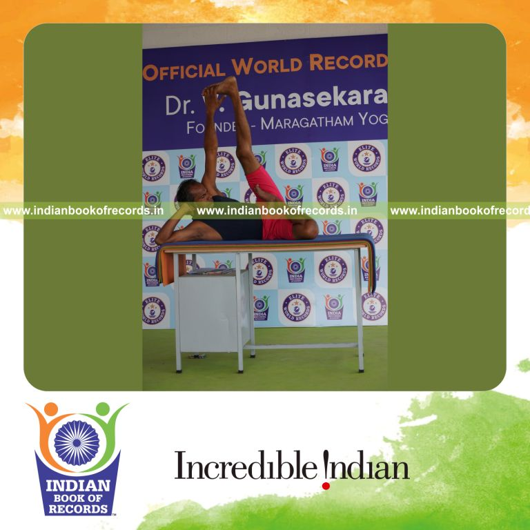 individual holding vama ardha padma anantasana yoga pose on a table for record in Indian Book of Records
