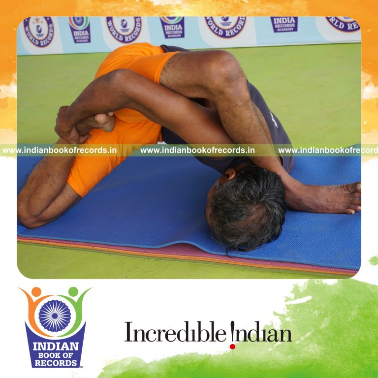 individual holding vama ardha padma astavakrasana yoga pose for record in Indian Book of Records