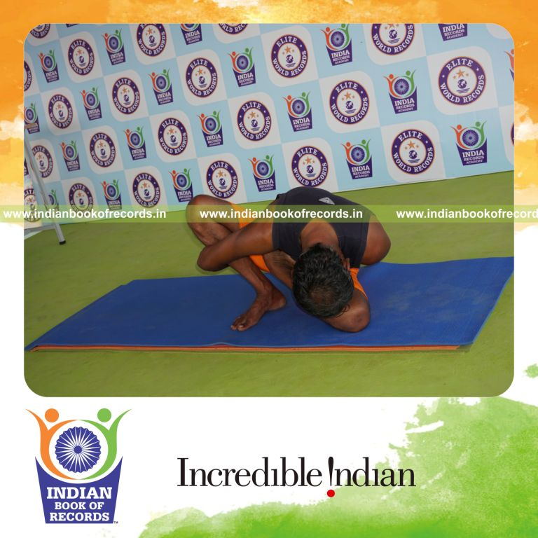 individual holding vama ardha padma marichyasana yoga pose blindfolded for record in Indian Book of Records