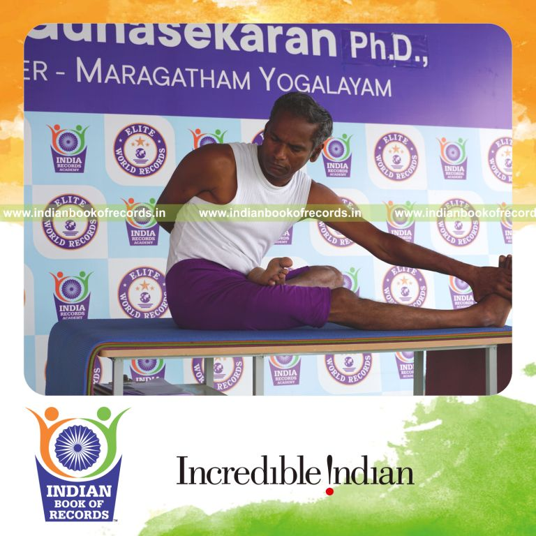 individual holding vama ardha padma matsyendrasana yoga pose on a table for record in Indian Book of Records